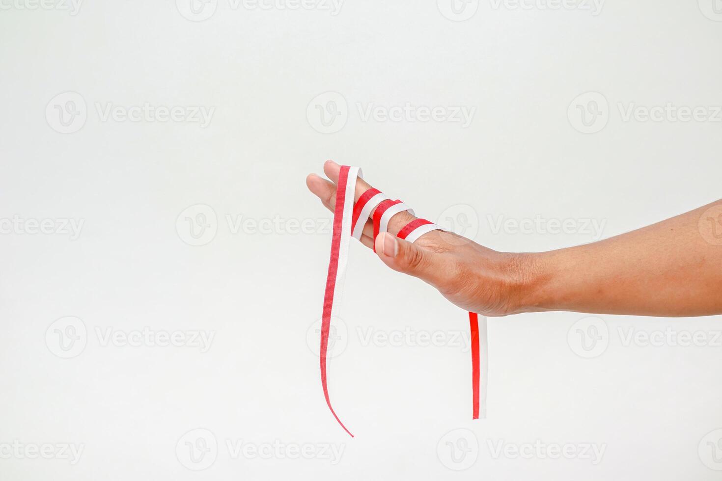 Hand holding the red and white ribbon, a symbol of Indonesian Independence Day concept photo