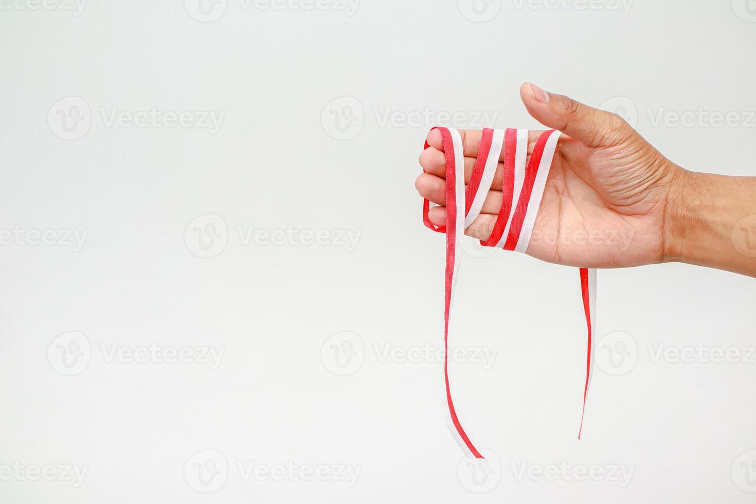 Hand holding a Red and White Ribbon on an Isolated White Background, Celebration photo