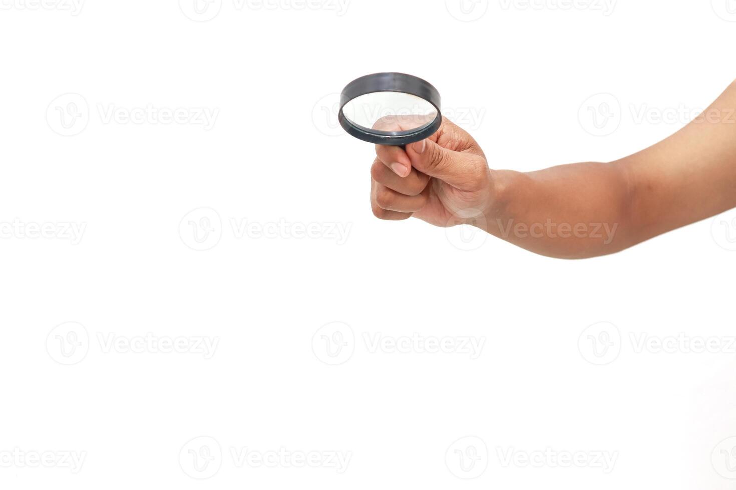 Hand holding a magnifying glass up close on a white background photo