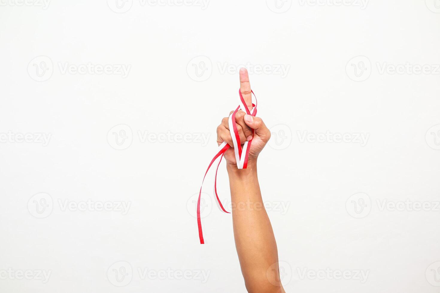 Celebrating Indonesian Independence Day with a Raised Hand and Red and White Ribbon photo