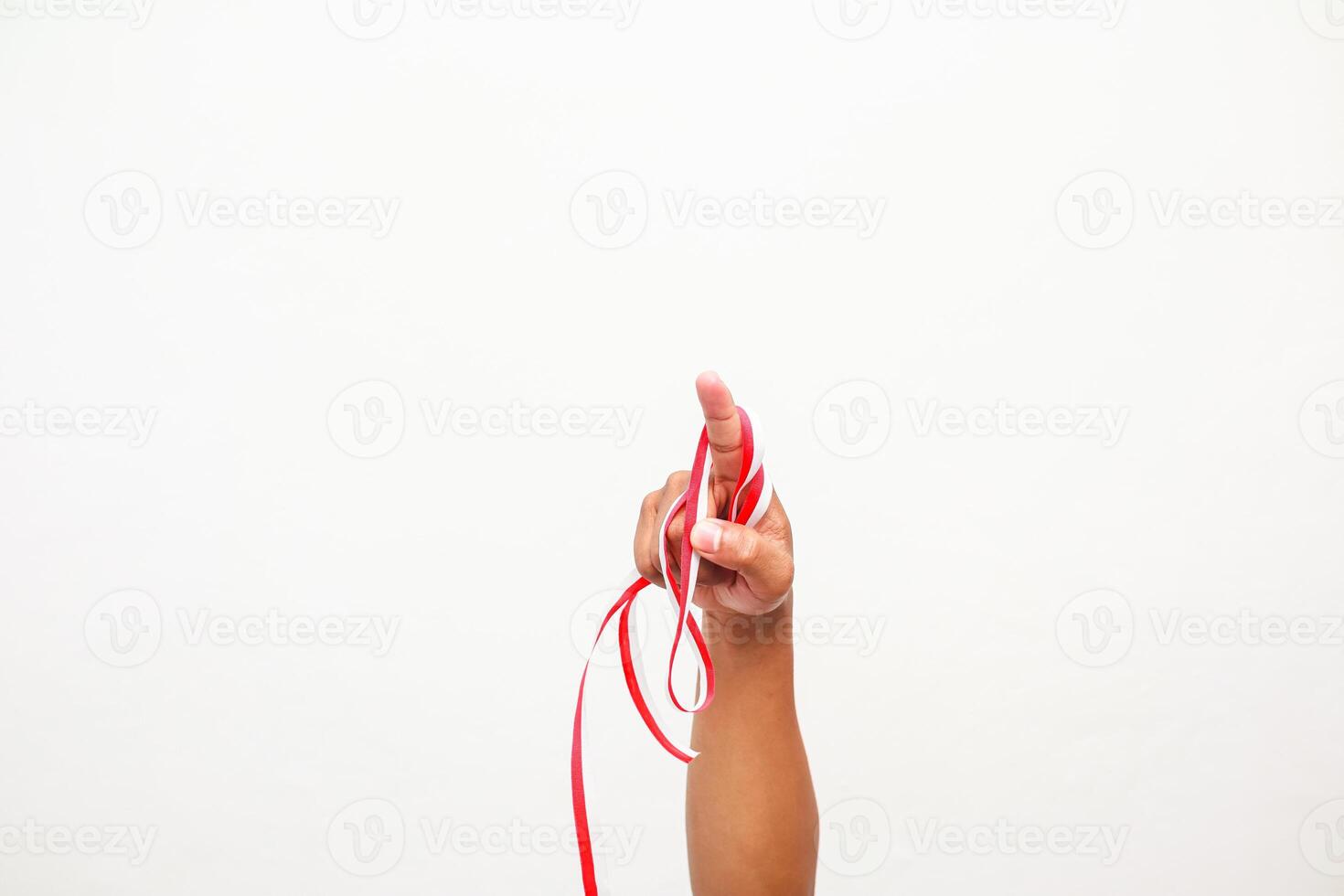Hand holding Indonesian red and white ribbon for independence day celebration concept photo