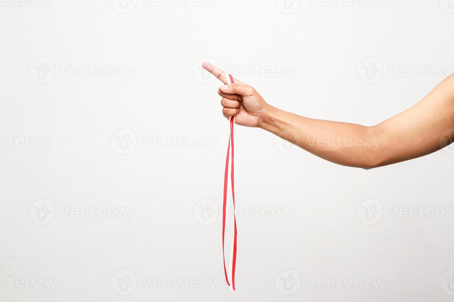 Hand holding an Indonesian flag colored ribbon, celebrating Indonesian Independence Day, with clear pointing finger photo
