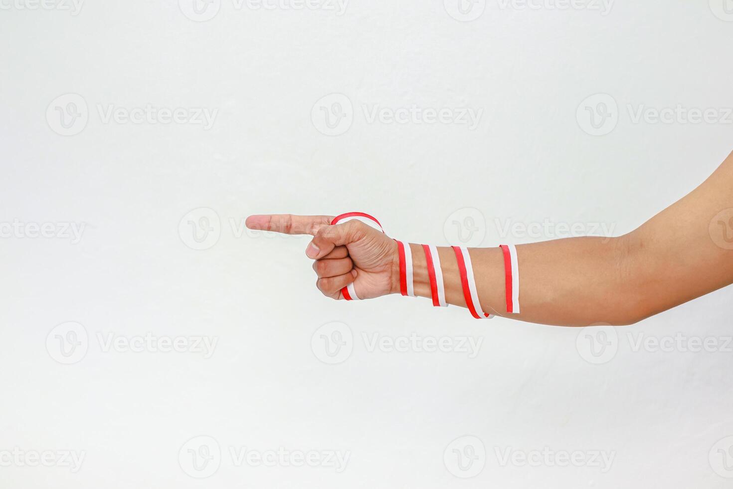 Hand pointing with red and white ribbons symbolizing Indonesian Independence Day celebration photo