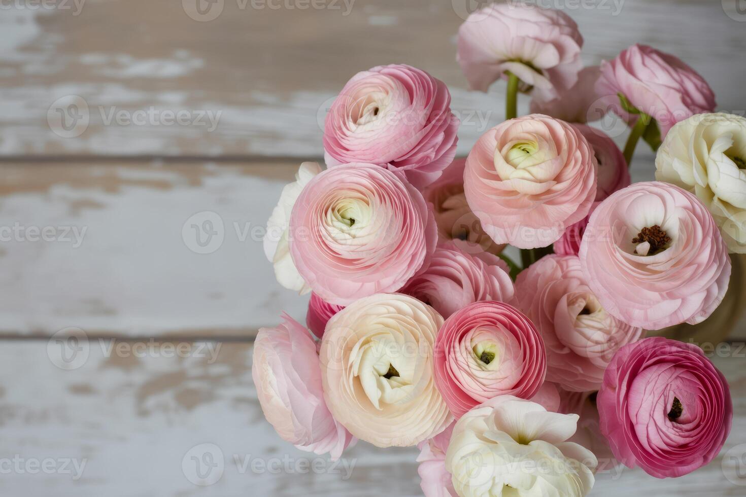 Elegant Pink Ranunculus Flowers Displayed on a Rustic Wooden Surface Creating a Soft Romantic Floral Arrangement photo