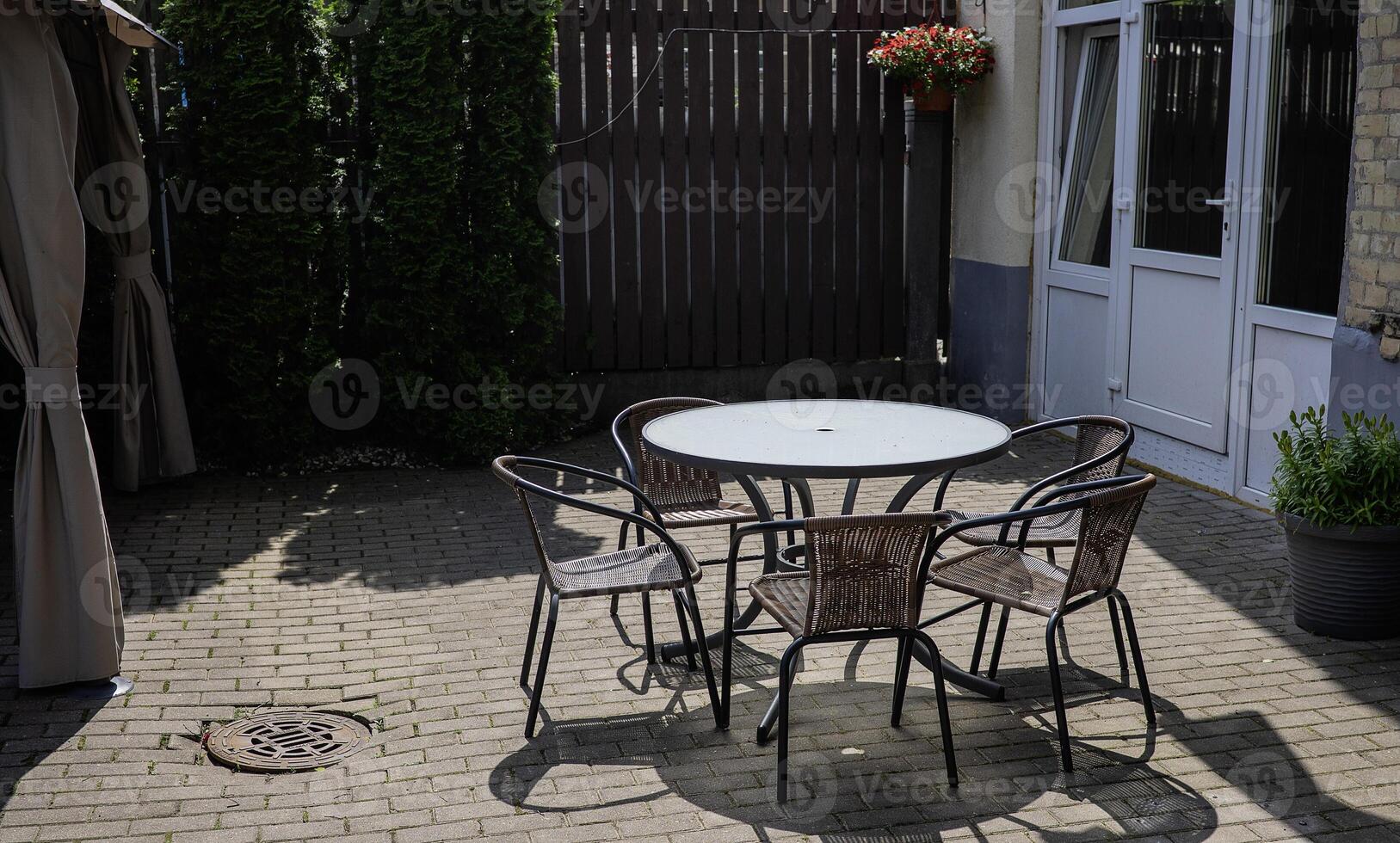 Metal chairs and oval table outside in the sunny day photo