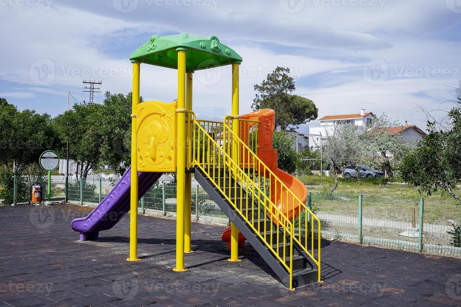 A playground with a slide and a green tower photo