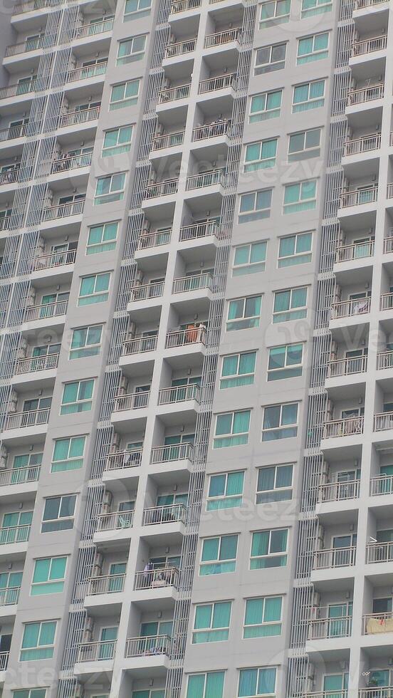 A close-up of a tall city apartment tower with symmetrical balconies in Bangkok, representing vertical living and urban development in the Thai capital. photo