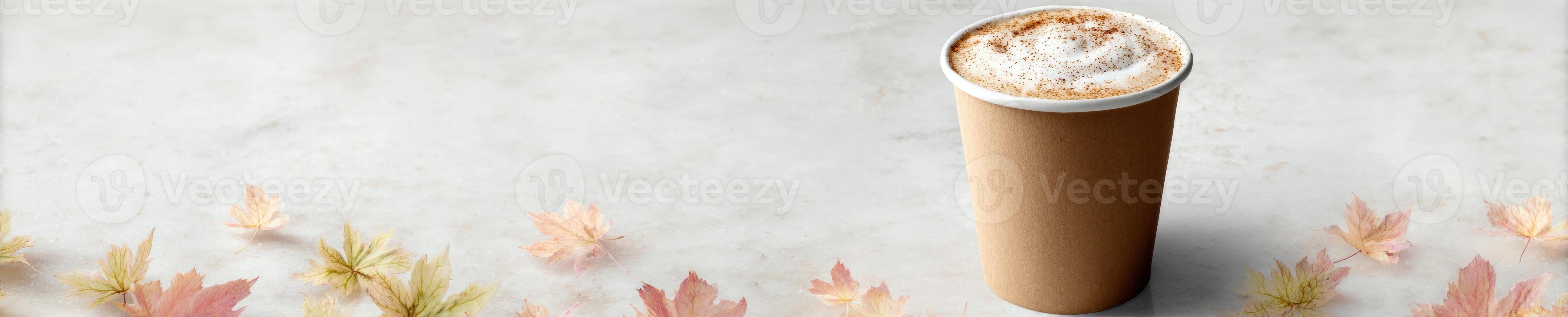 Autumn warmth with pumpkin spice latte in a to go cup on marble with colorful leaves photo