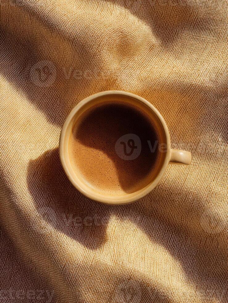 Top view of coffee cup on textured caramel linen fabric for cozy kitchen decor photo