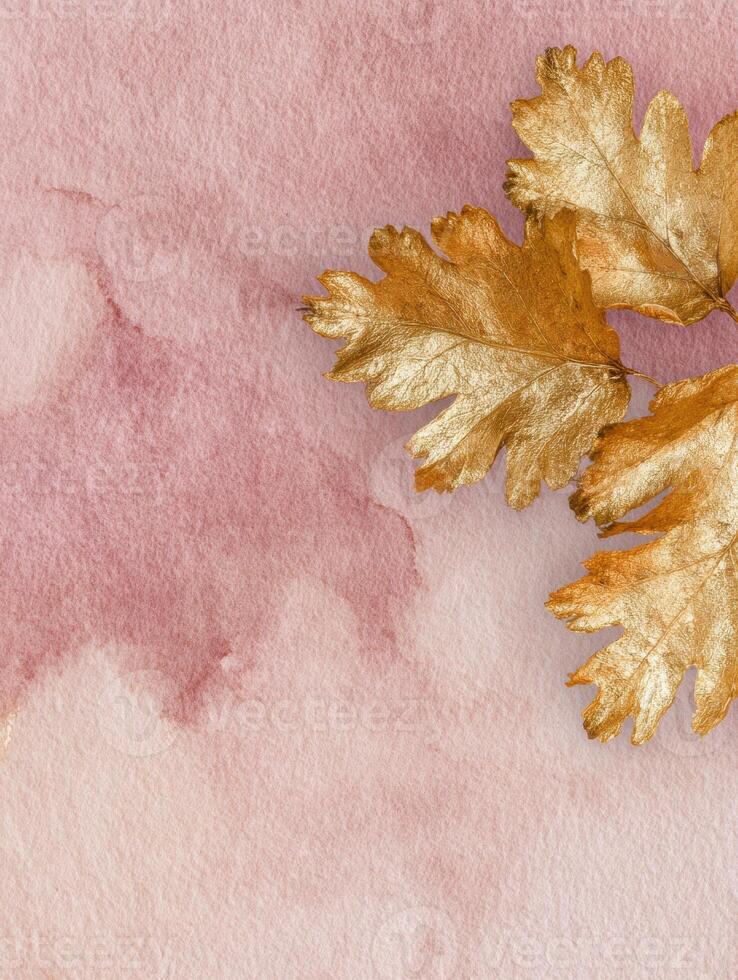 Elegant flat lay with golden leaves on pale dusty rose background for creative design photo