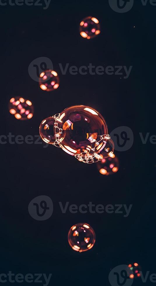 A collection of iridescent soap bubbles floating against a dark, out of focus background image photo