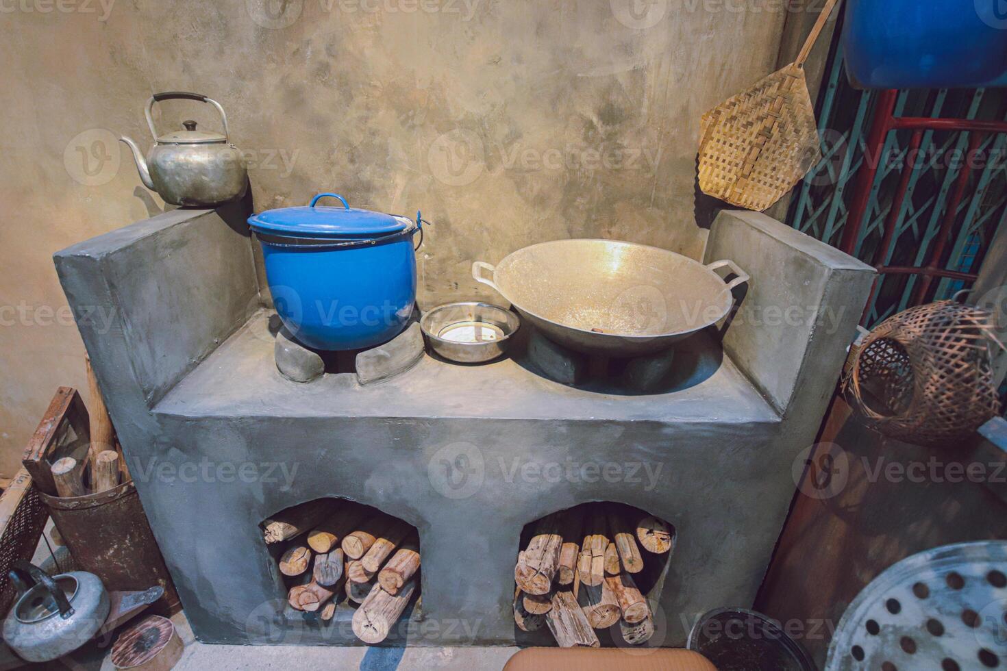 Horizontal image of a rustic Thai kitchen with firewood cooking setup. Clay stoves and traditional tools reflect heritage cooking and a sustainable rural lifestyle. photo