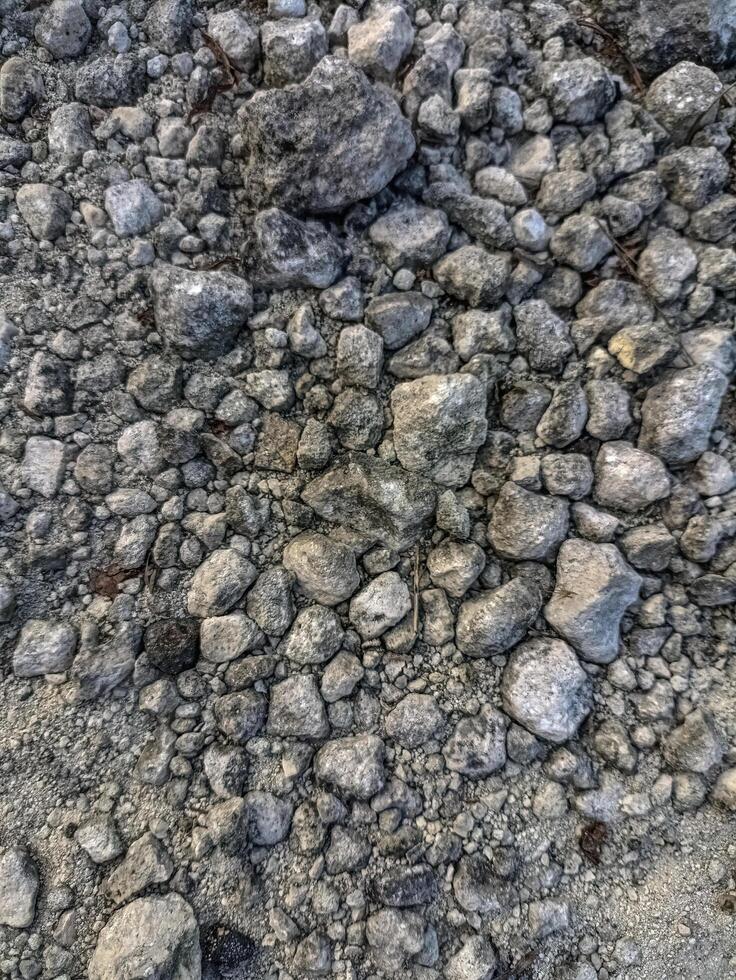 Close up of mixed gravel and natural pebbles in various sizes and tones, creating a raw, rough texture ideal for use in backgrounds, construction themes, or organic surface designs photo