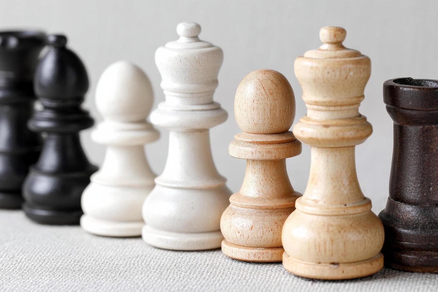 Chess pieces in black and white arranged in row on textured surface photo