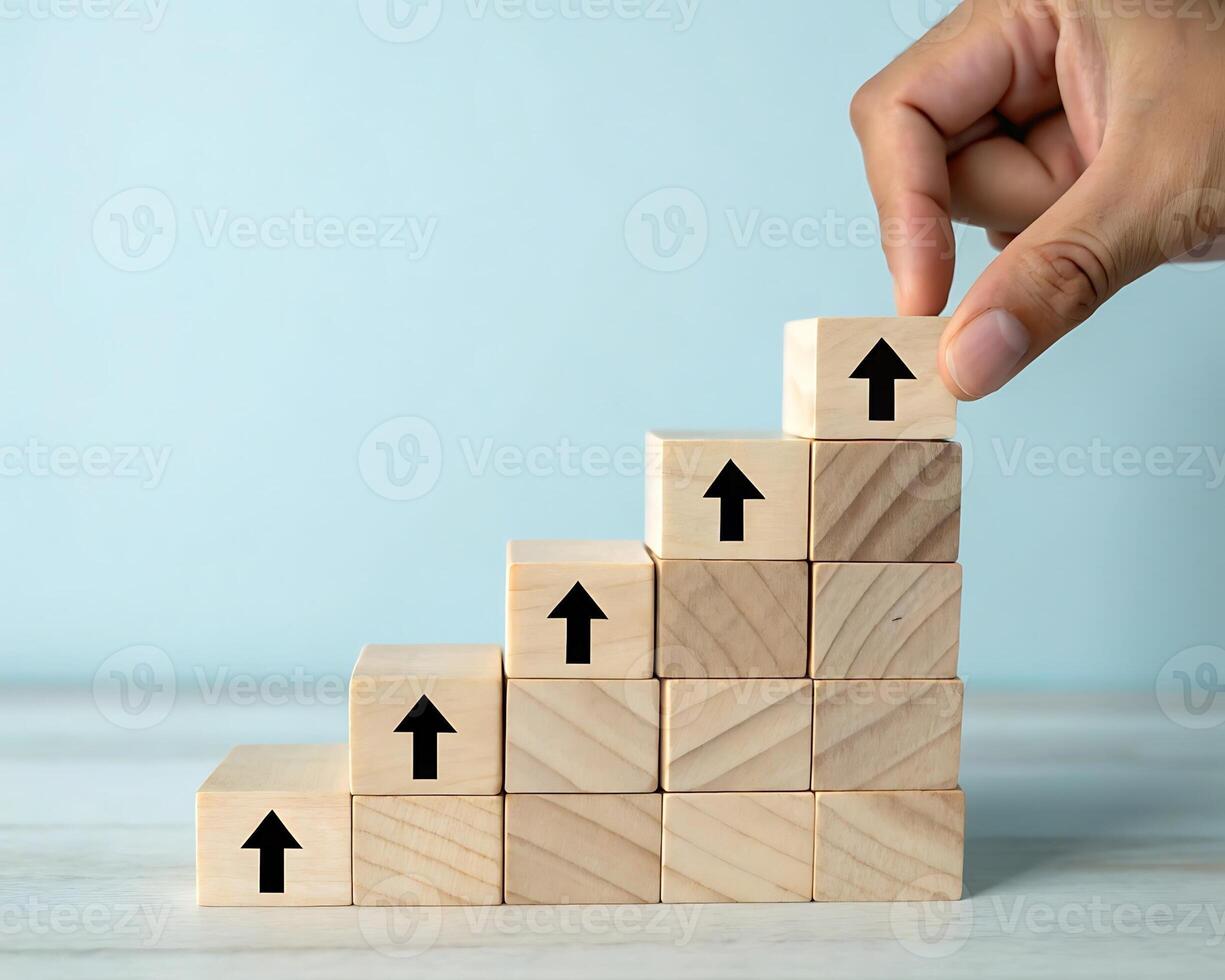 Hand placing wooden block with upward arrow on stair step isolated on white background photo