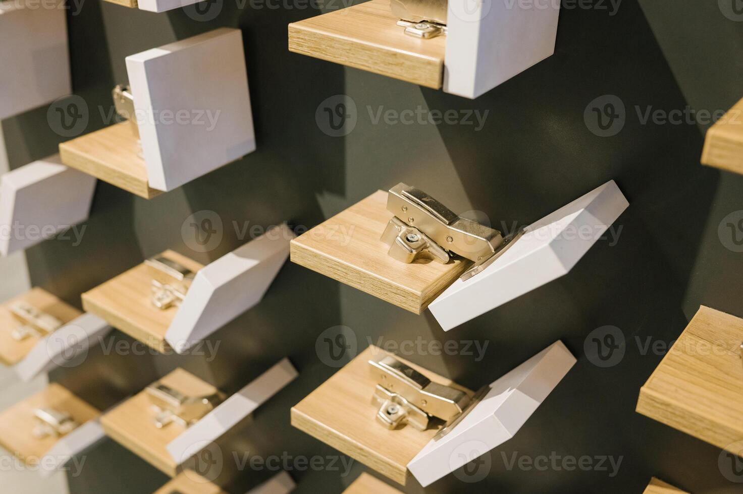Wall display of cabinet hinges on wooden blocks in hardware store photo