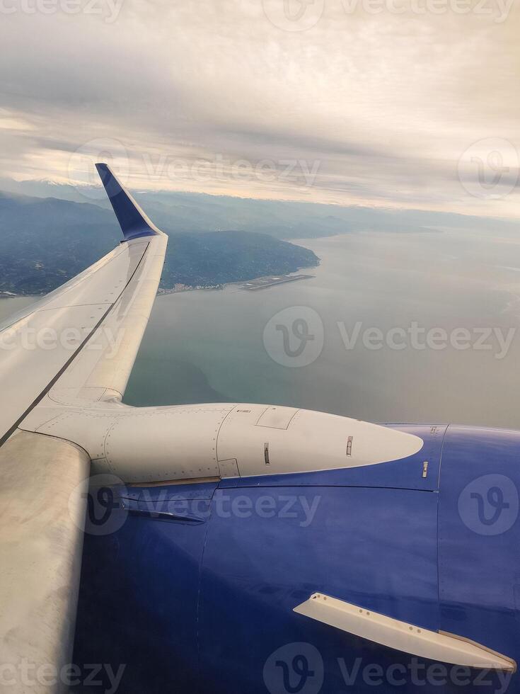 beautiful thick clouds in sky from the height of the flight of the plane with a view of the wing with engines photo