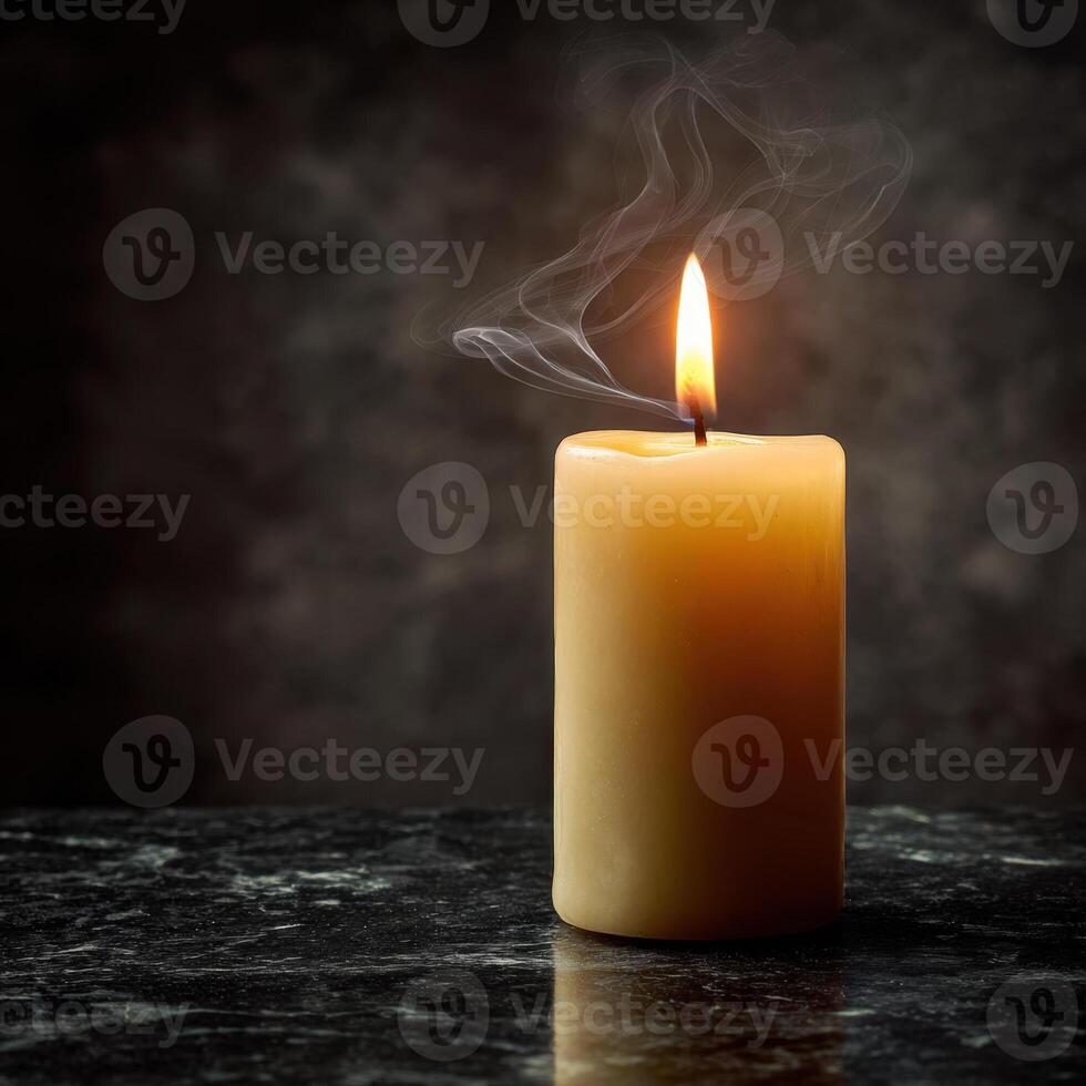 A single candle is lit on a dark background photo