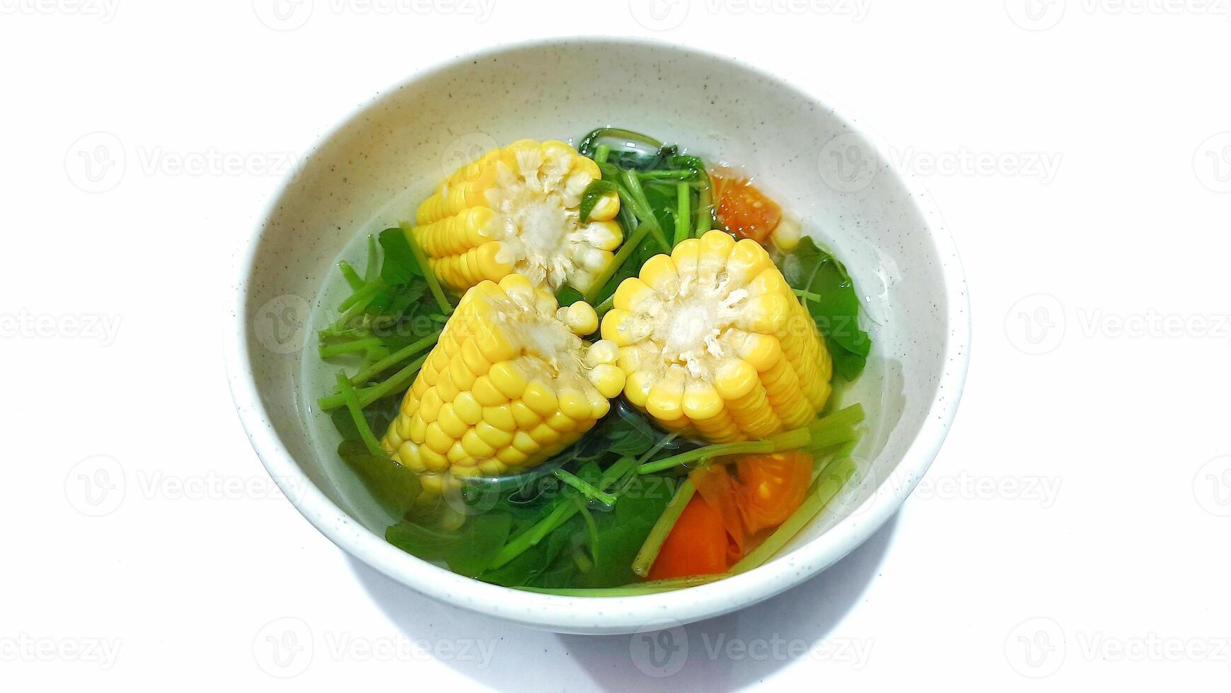 Spinach Clear Soup with Corns. Sayur bening bayam jagung served in white bowl, Indonesian popular food photo