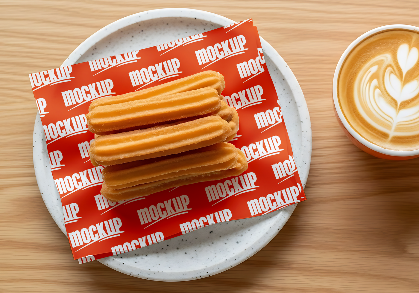 A stack of churros rests on a red and white patterned napkin next to a cup of latte art coffee psd