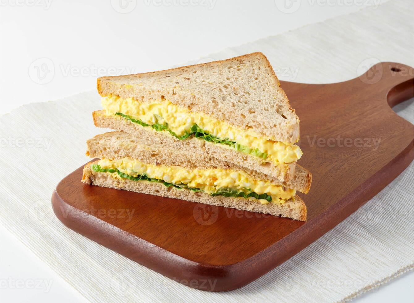 Classic Egg Mayo Sandwich on Whole Wheat Bread isolated on wooden board side view of Perfect for Quick Lunch or Snack photo