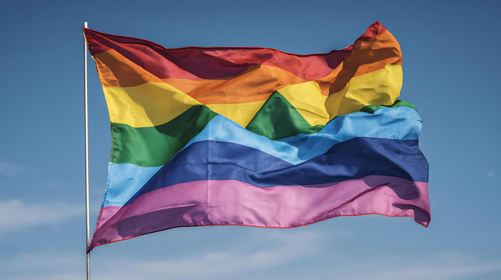 Vibrant Rainbow Flag Waves Proudly Against a Clear Blue Sky. photo