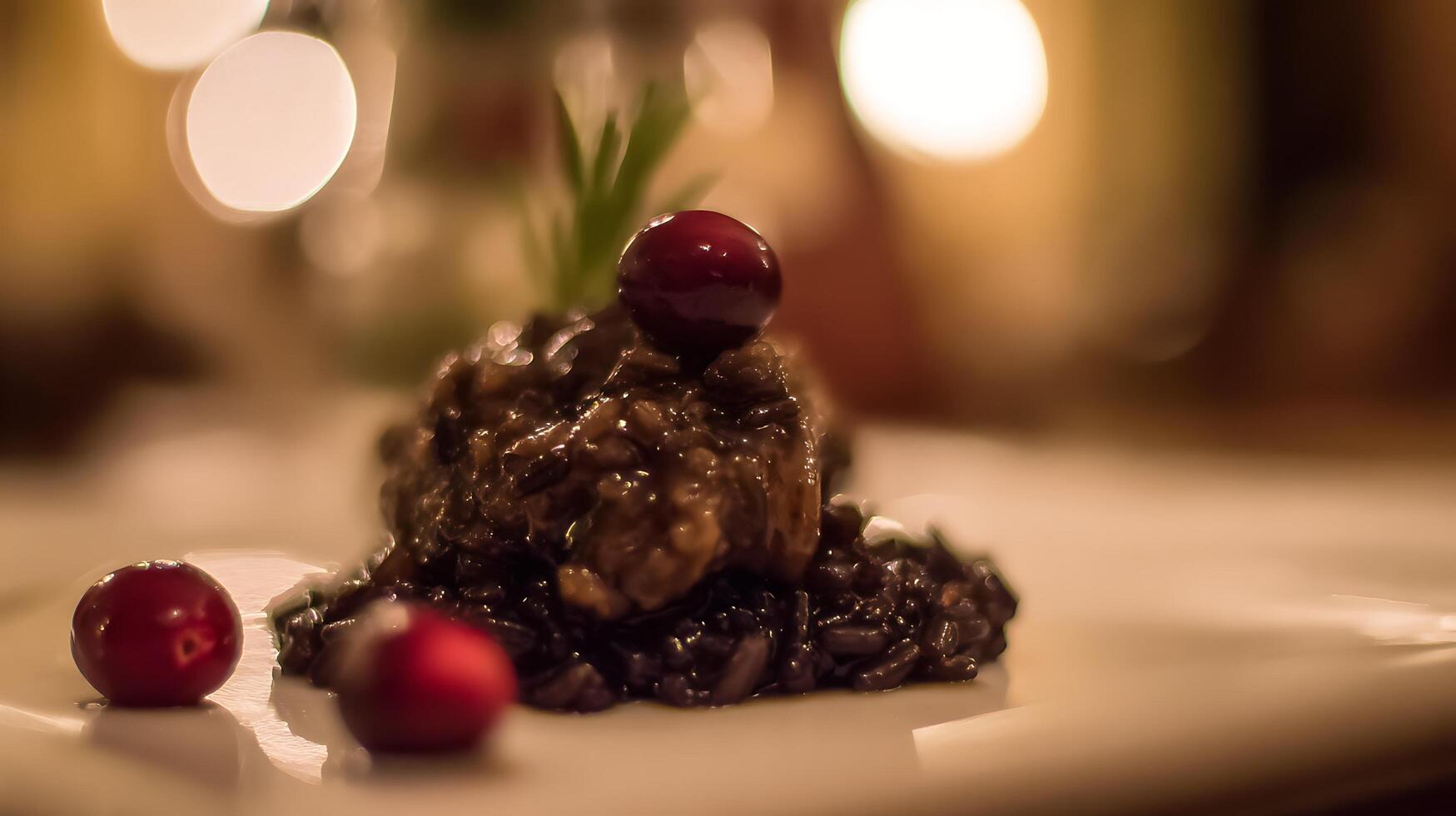 Gourmet Black Rice Dish with Cranberry Garnish and Soft Bokeh Lights. photo