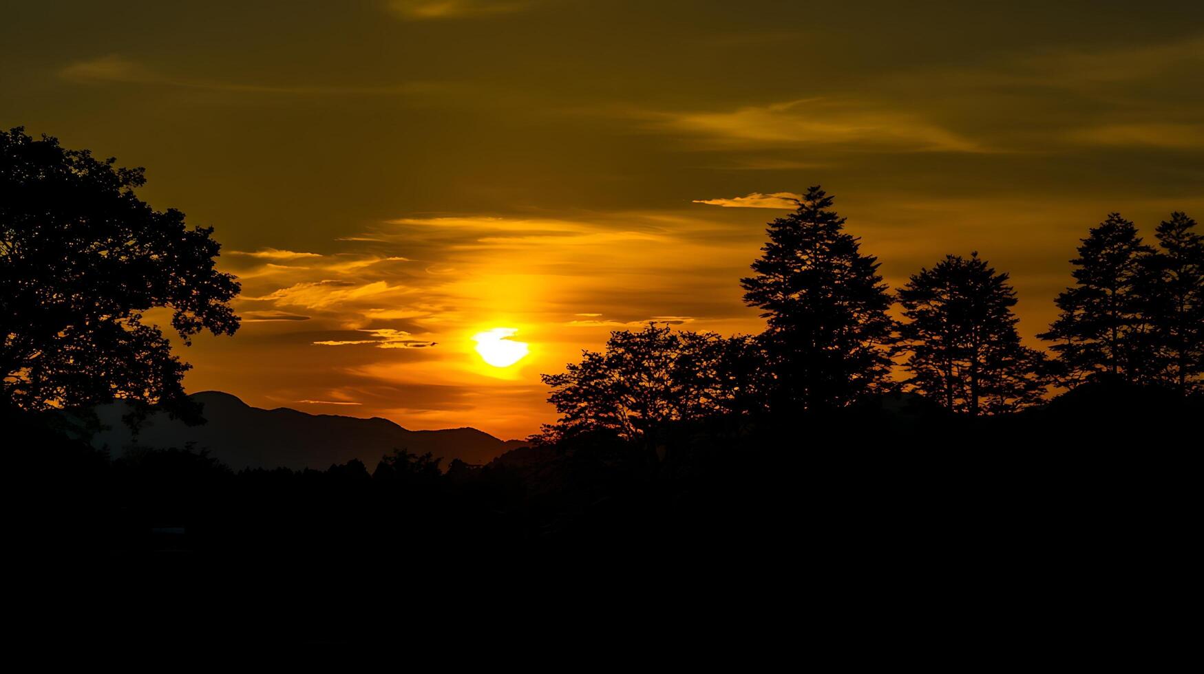 Golden Sunset Over Mountains Silhouetted Against Dramatic Skies. photo