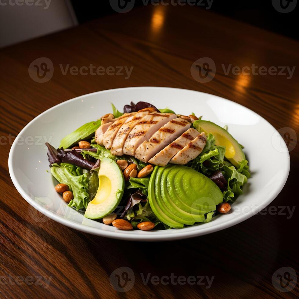 Healthy grilled chicken salad with avocado, almonds, and fresh mixed greens photo