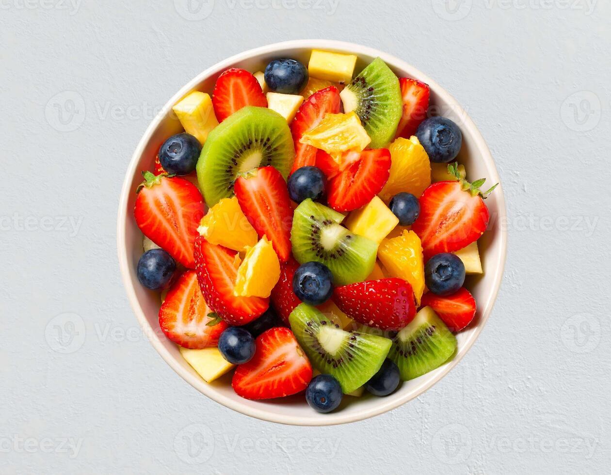 A bowl of fresh fruit salad with kiwi, strawberries, blueberries photo