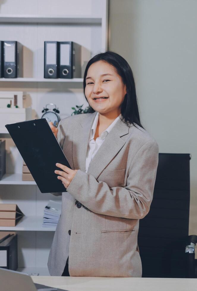 Asian businesswoman holding a clipboard in office photo
