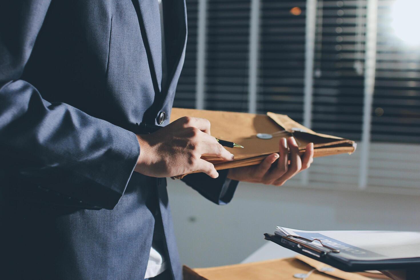 A man in a suit holding a folder photo