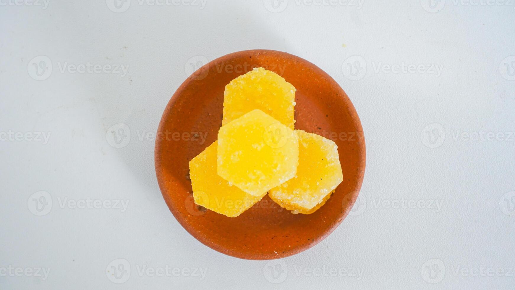 Top view of stack of traditional Indonesian sugar cubes on a clay plate isolated on white background photo