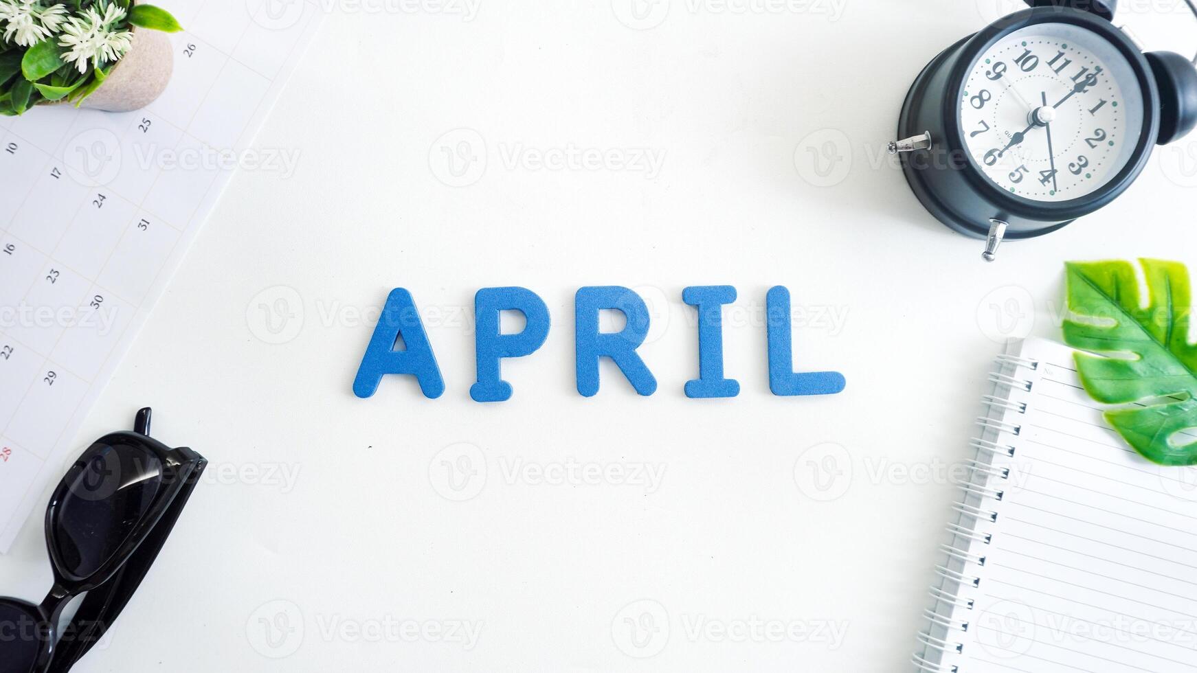 Flat lay composition with blue color foam letters spelling word APRIL isolated on white background photo