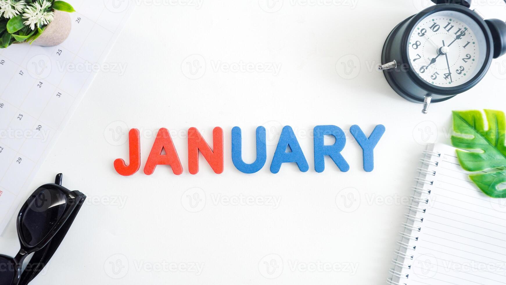Flat lay composition with red and blue color foam letters spelling word JANUARY isolated on white background photo