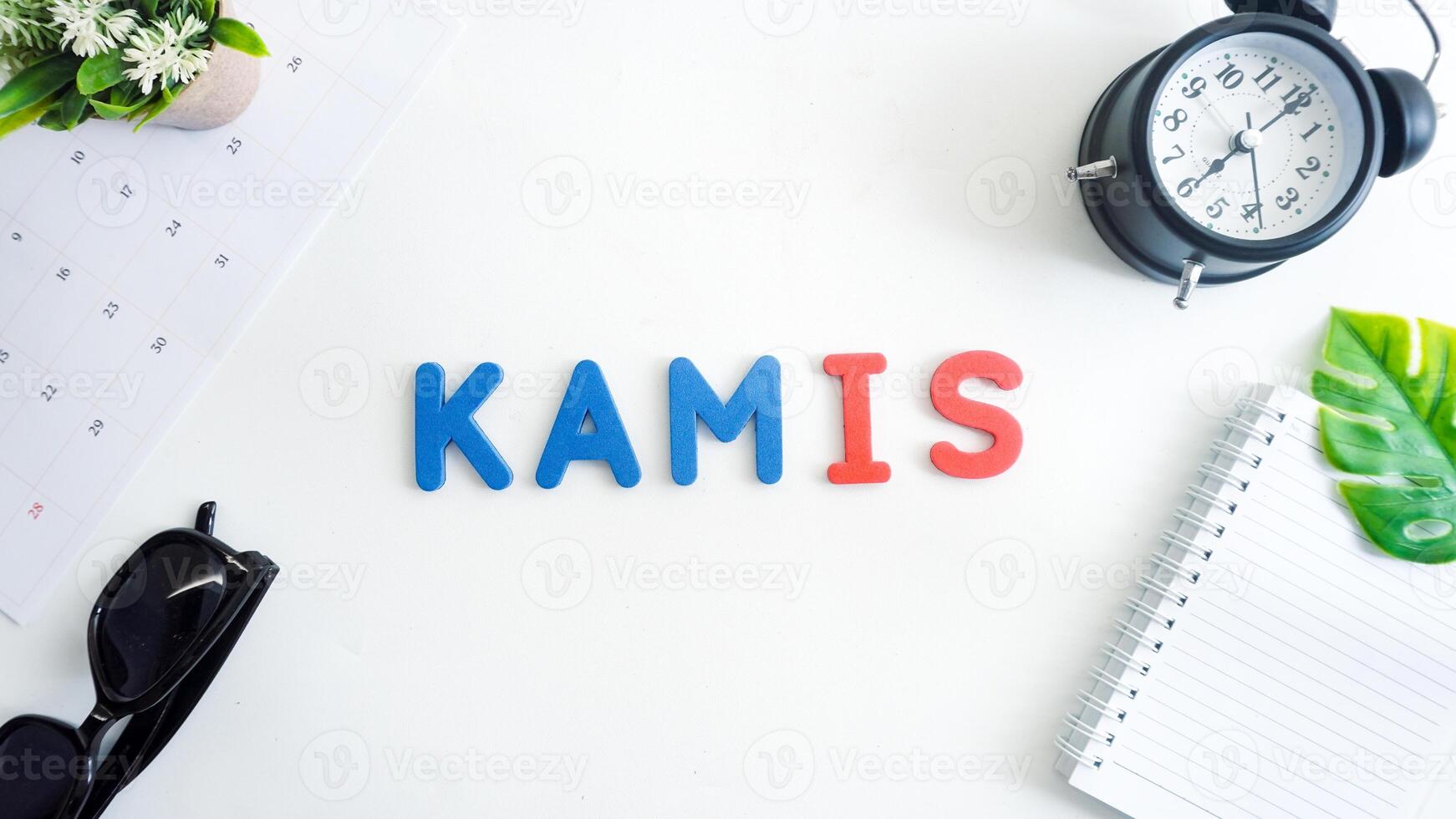 Flat lay composition with red and blue color foam letters spelling word thursday in Indonesian, KAMIS isolated on white background photo