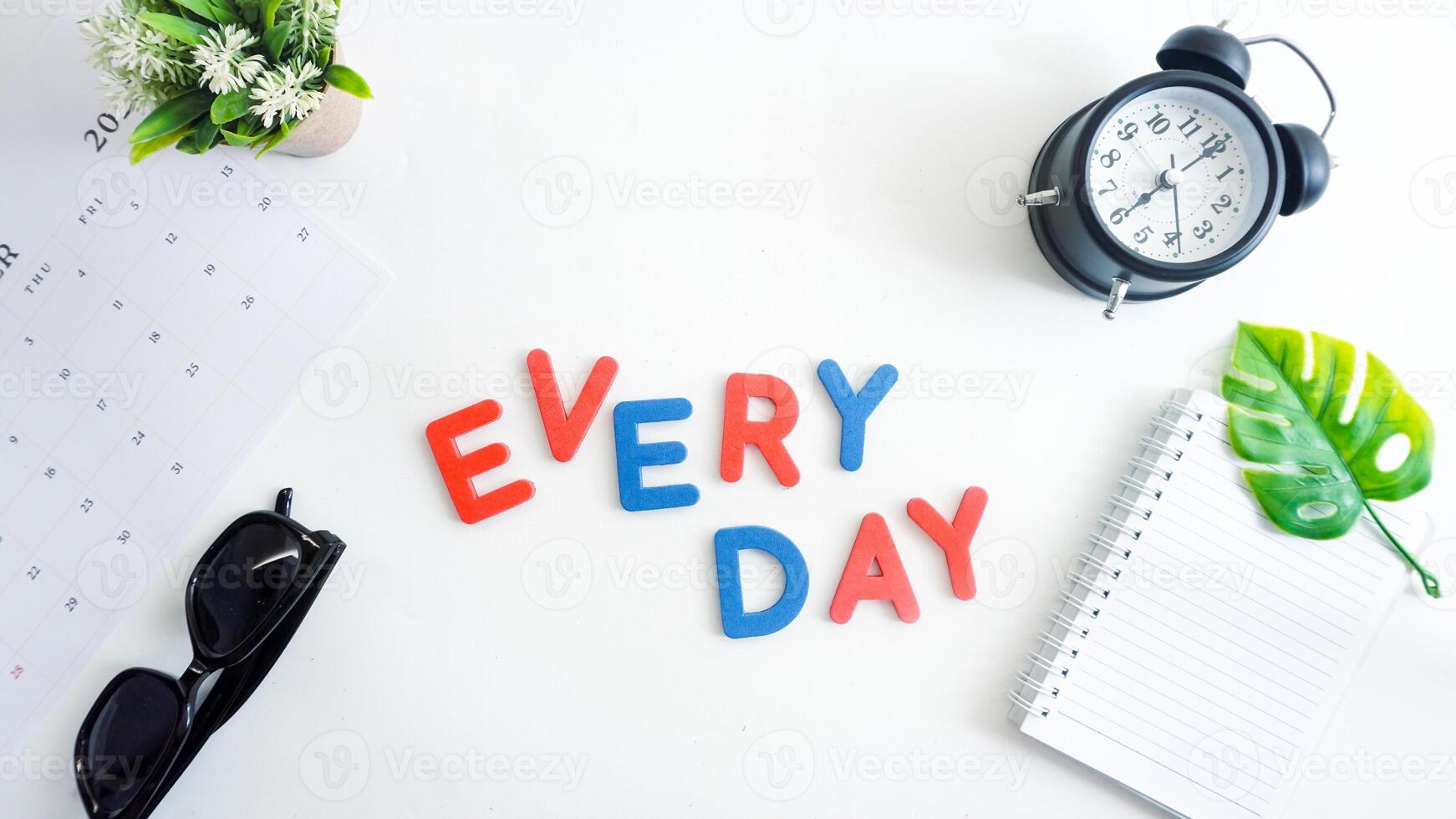 Flat lay composition with blue and red color foam letters spelling word EVERY DAY isolated on white background photo