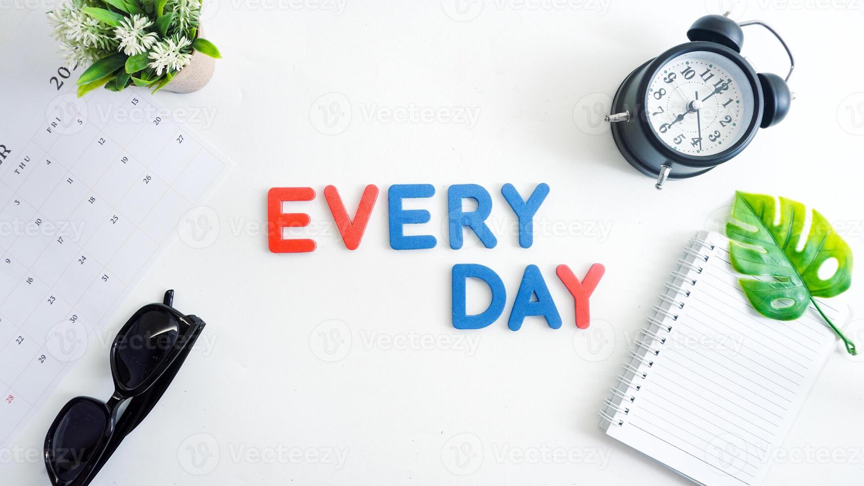 Flat lay composition with red and blue color foam letters spelling word EVERYDAY isolated on white background photo