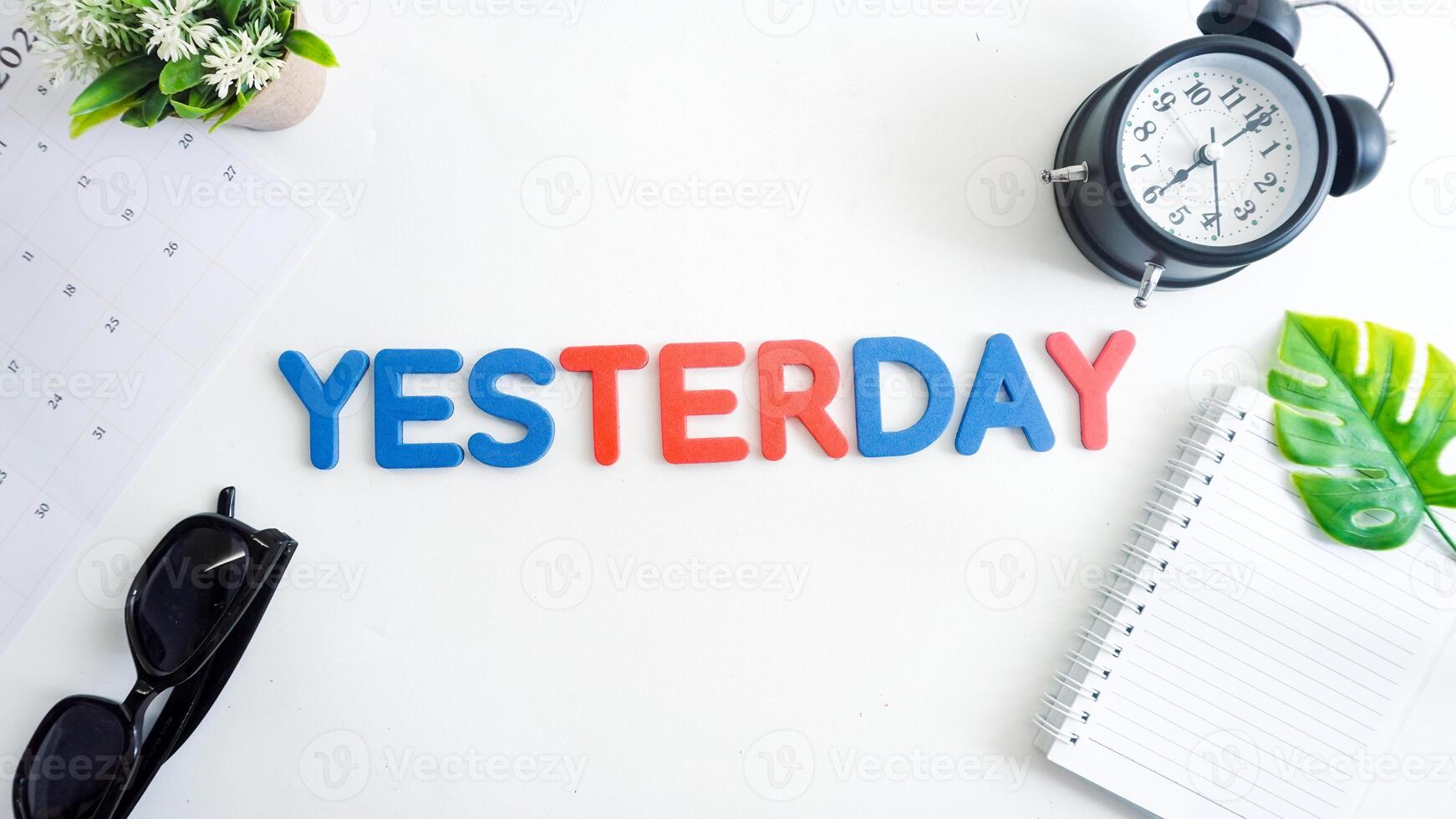 Flat lay composition with blue and red color foam letters spelling word YESTERDAY isolated on white background photo