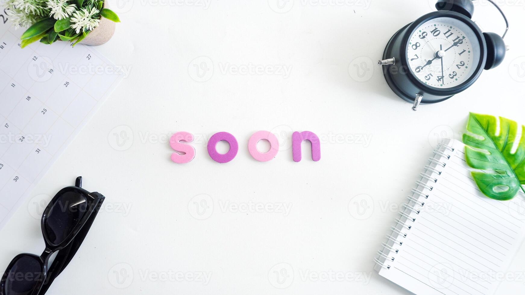 Flat lay composition with colorful foam letters spelling text SOON isolated on white background photo