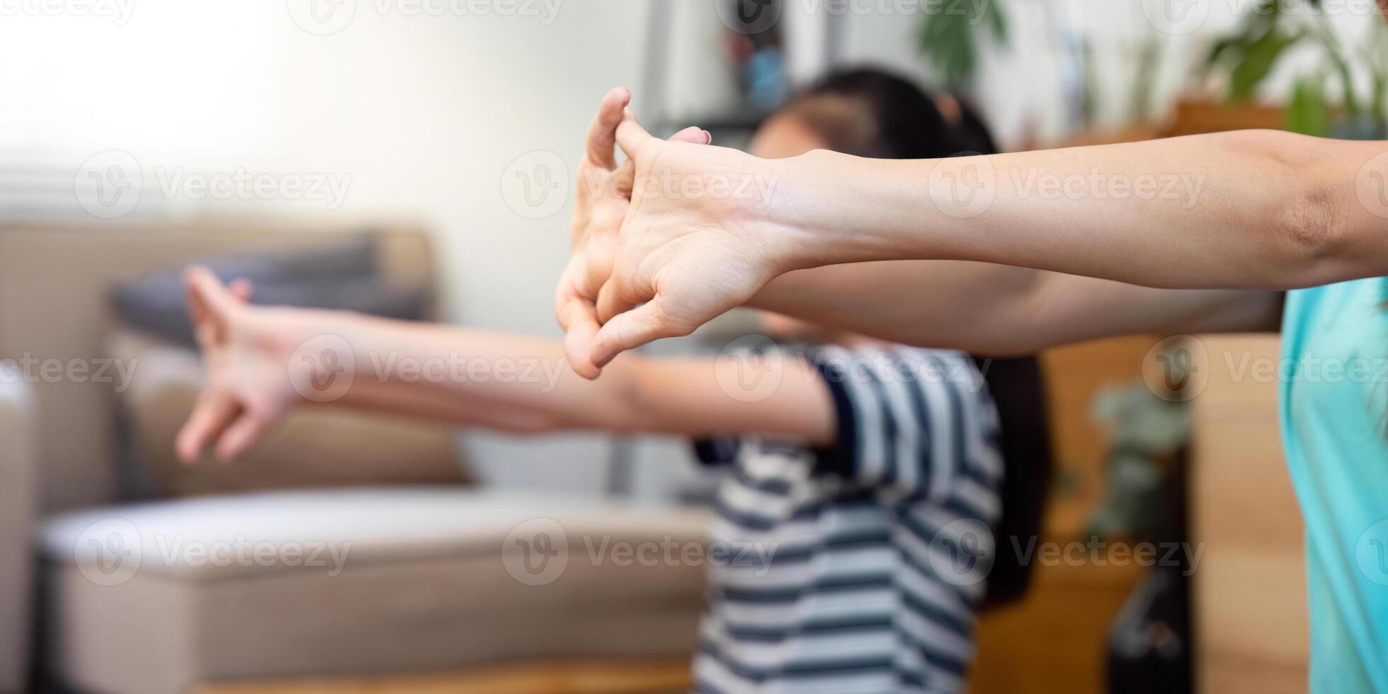 Mother and daughter practicing stretching exercises at home photo