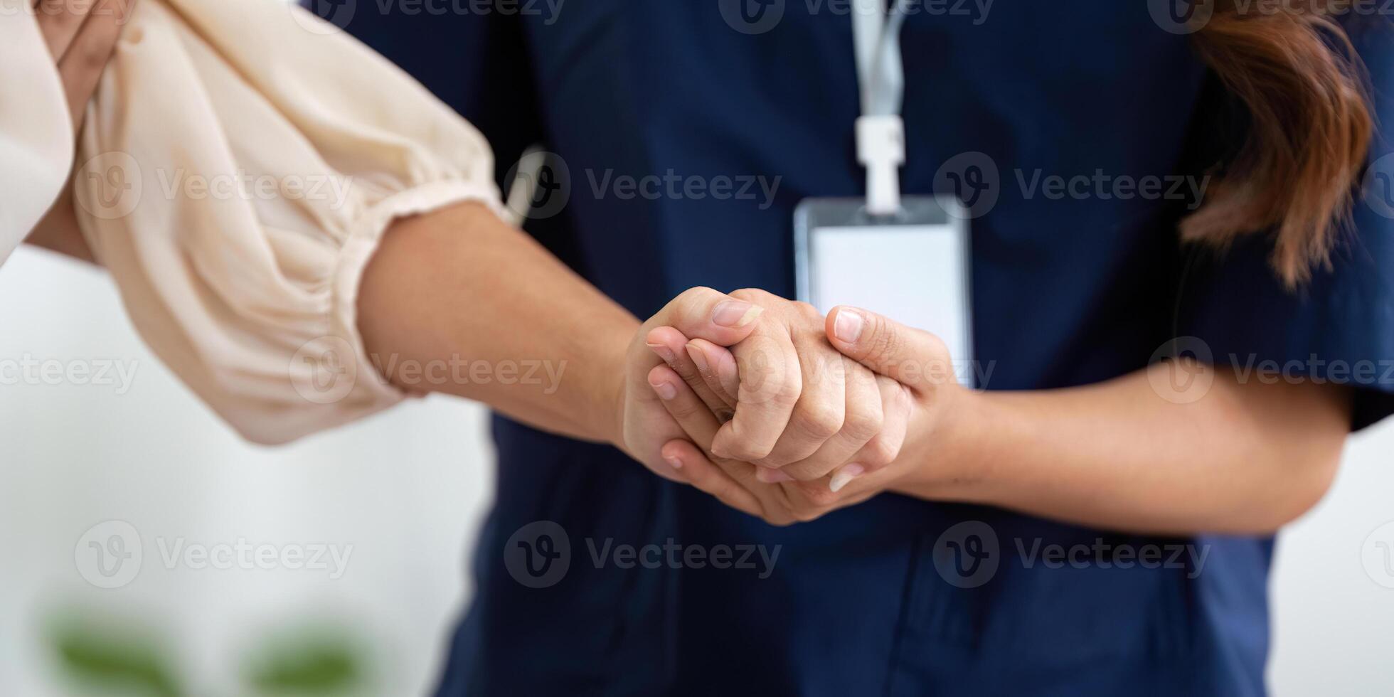 Caregiver providing hand support to elderly woman in home environment photo