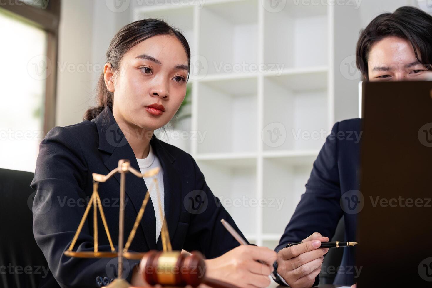 Legal Consultation. Young female lawyer discussing case details with client in office. photo