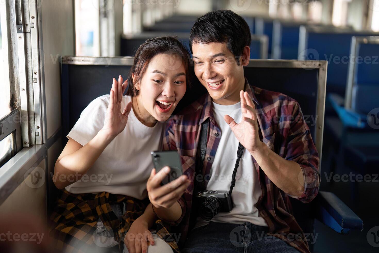 Couple laughing and waving while calling on a train photo