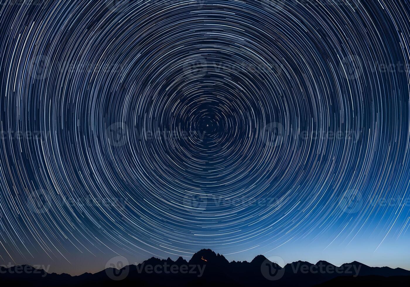 star trails over mountains in the night sky photo
