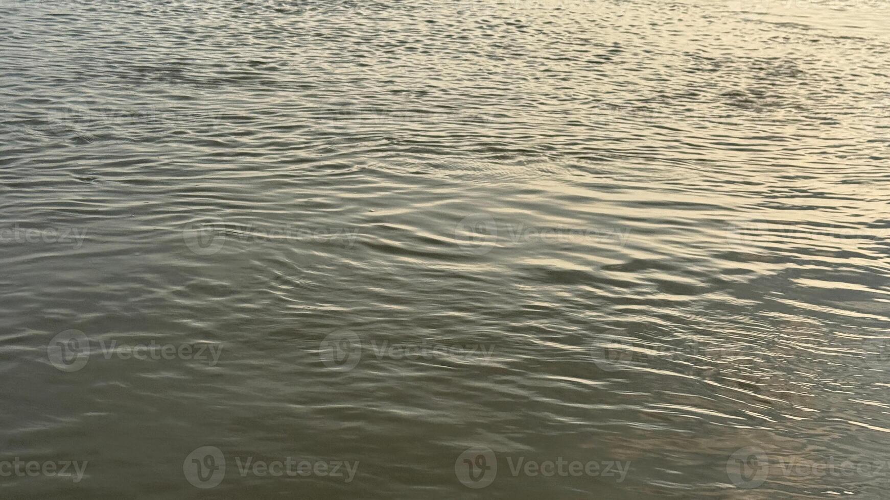 Gentle ripples and subtle reflections create a calming water surface at dusk photo