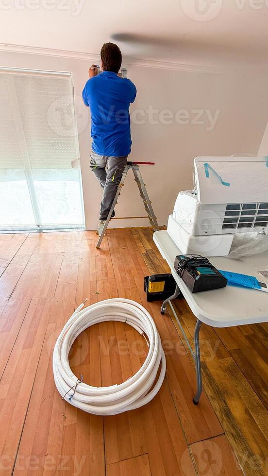 A dedicated worker, possibly Hispanic male, installs futuristic climate magic during spring refreshment, evoking World Plumbers Day efficiency photo