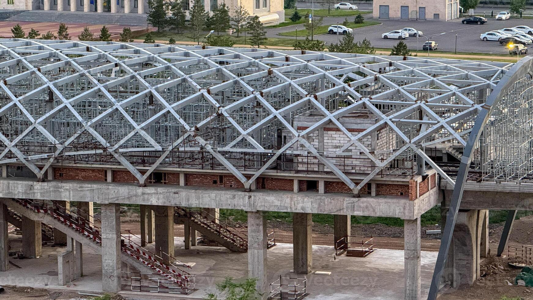 Crisscrossing steel canopy kisses concrete colossus, evoking urban metamorphosis and industrial steampunk dreams, celebrating World Architecture Day photo