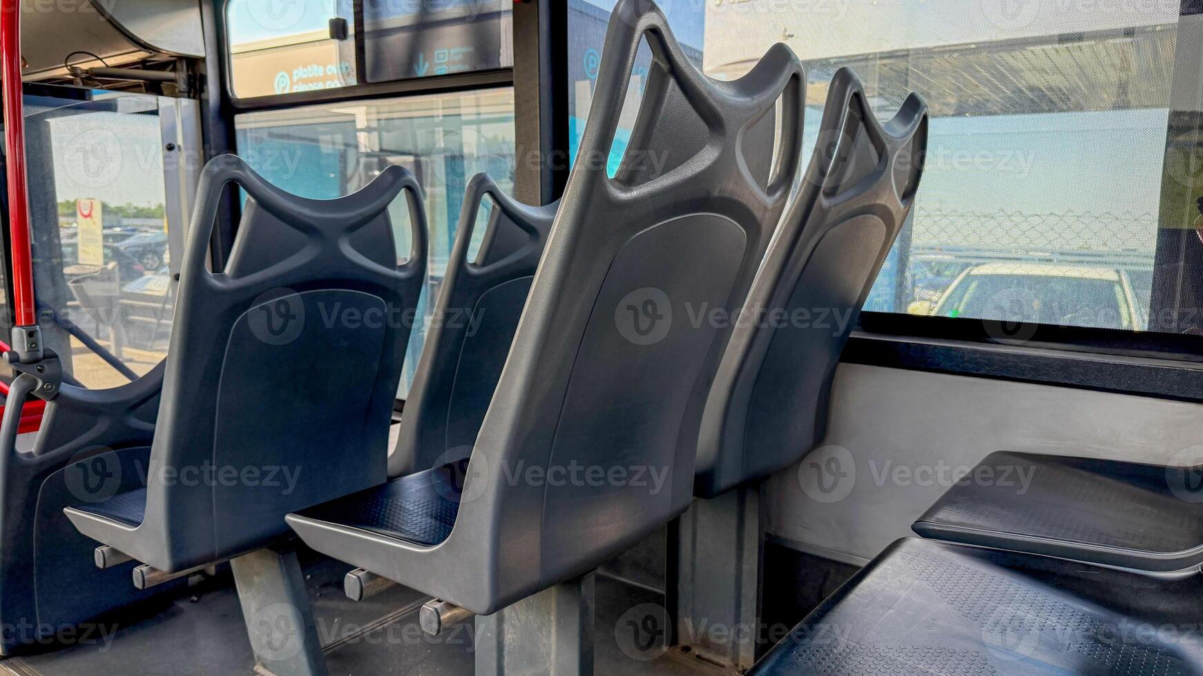 Empty bus seats basking in urban sunlight, silent witnesses to commuter tales, evoke Public Transport Day reflections photo