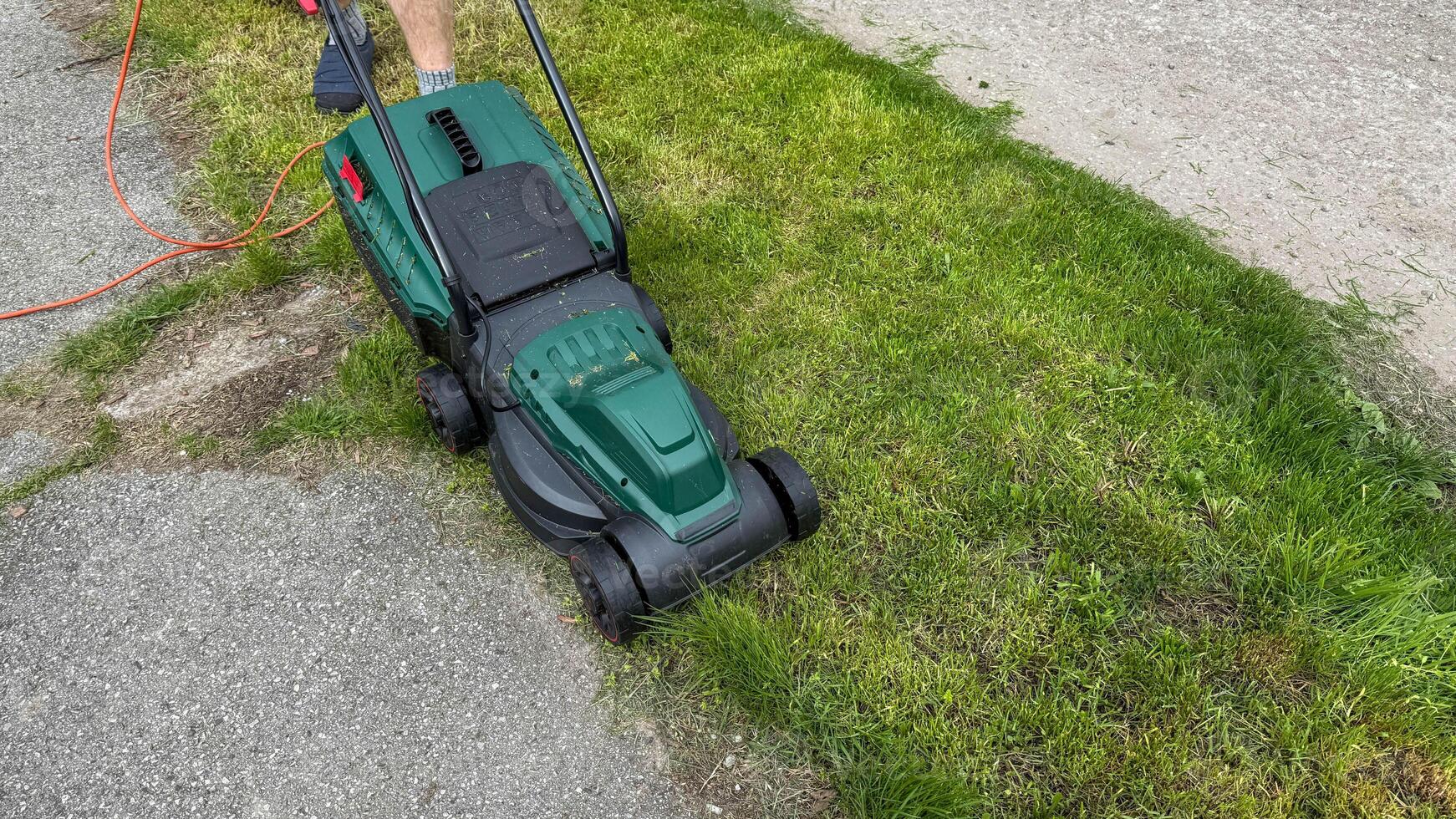 Electric green mower gliding over lush grass, whispering La Semana del Jardin, eco friendly rituals of joyous tinkering photo
